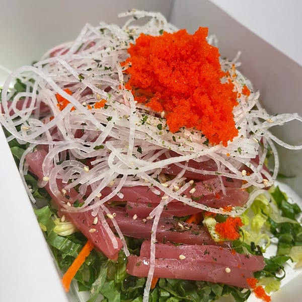 Ryuu Bowl's tuna poke bowl with tobiko, daikon, and greens in a white container.
