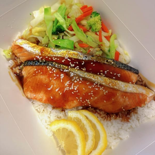 Ryuu Bowl's salmon teriyaki with white rice, mixed vegetables, and lemon slices.